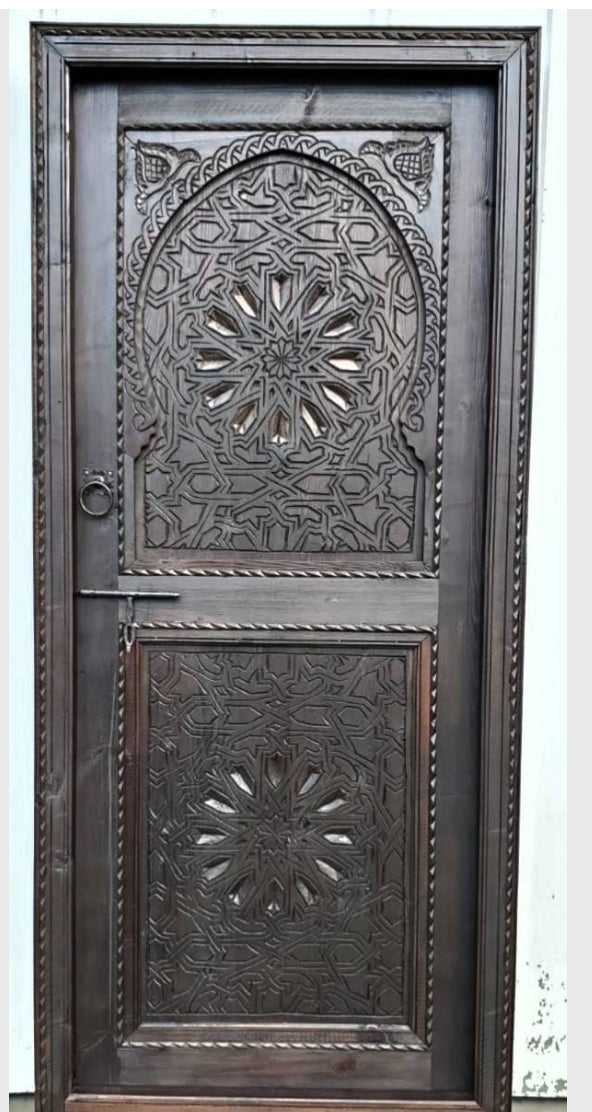 My Store Riad door featuring intricate wood carvings and traditional design with a warm finish.