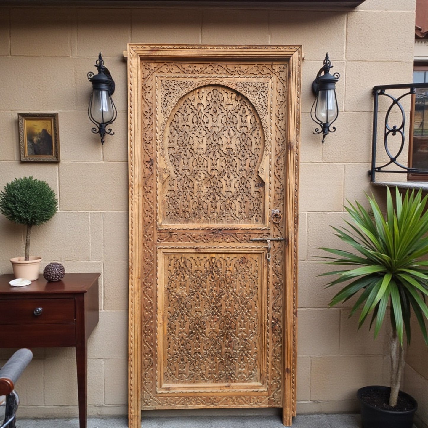 Decorative Andalusian door with intricate woodwork and traditional design, showcasing warm tones and detailed craftsmanship.