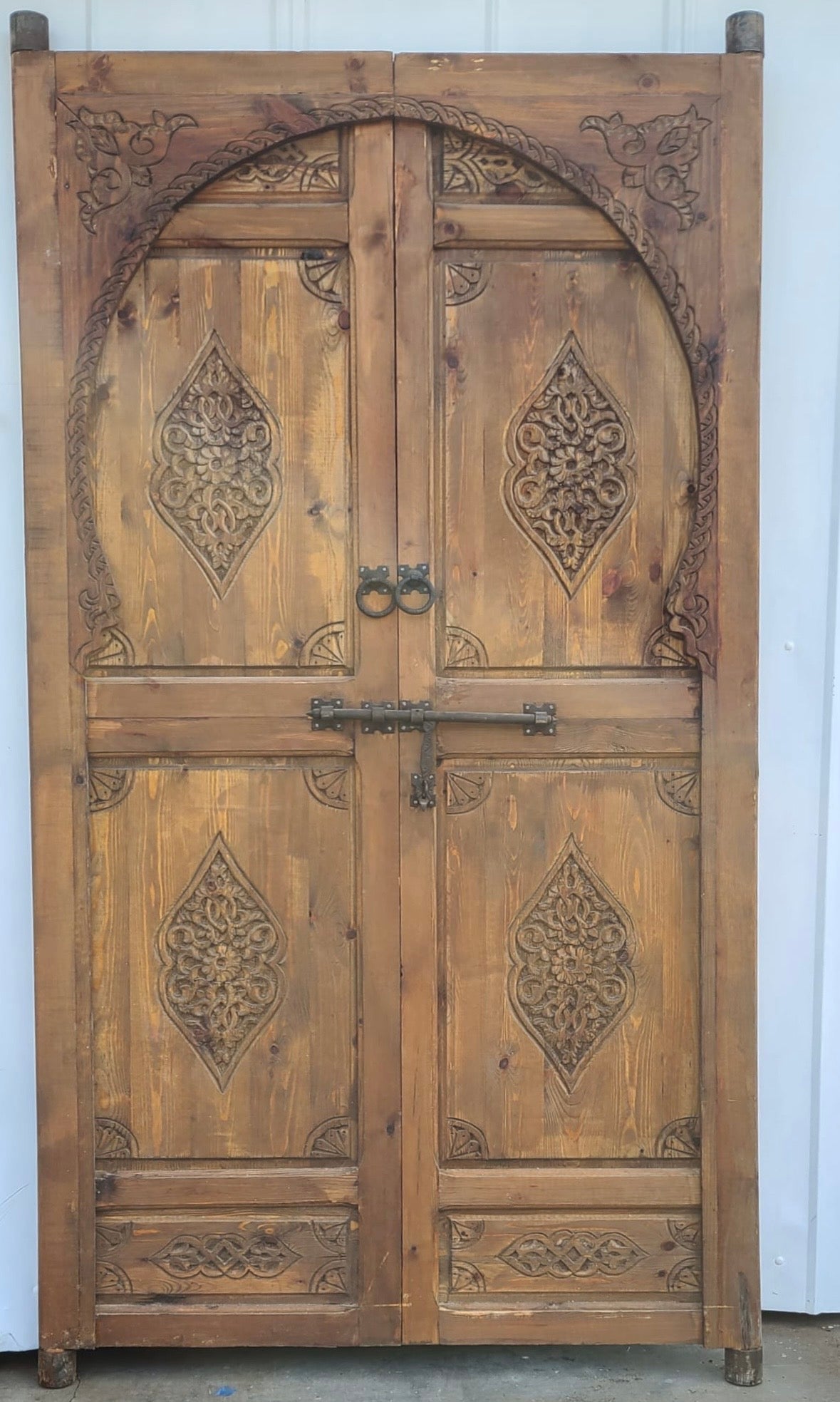 Moroccan Grand Andalusia door with intricate carved wood details and vibrant colors, showcasing traditional craftsmanship.