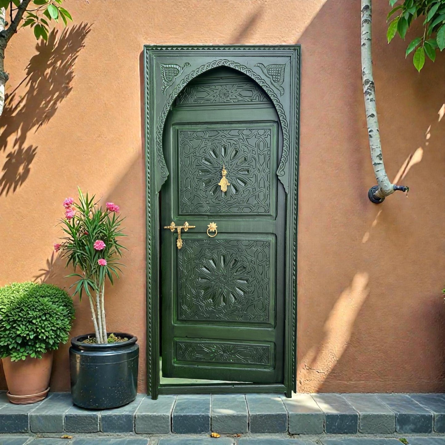 Green Andalusian wooden door with decorative carvings and iron hardware, showcasing traditional craftsmanship.