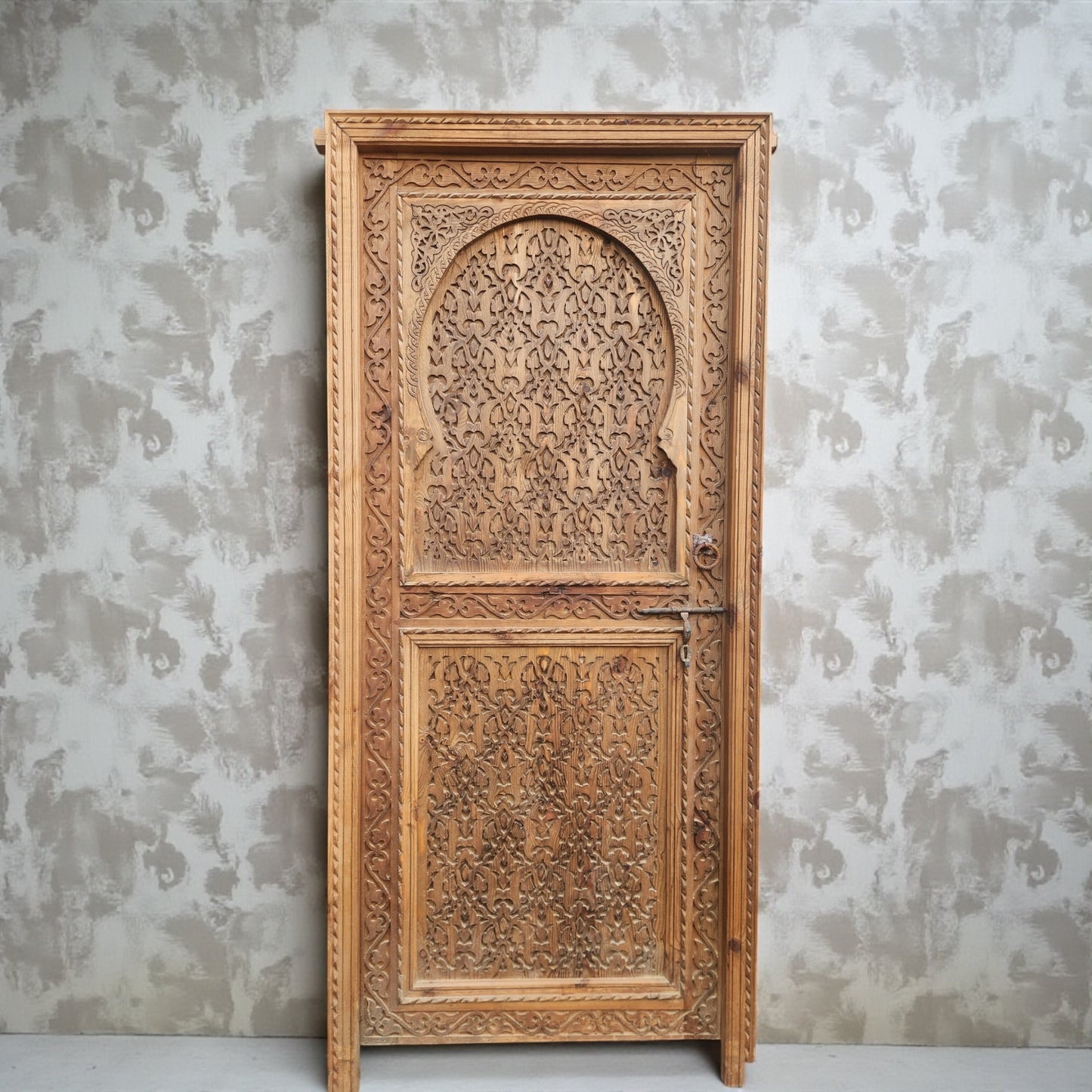 Andalusian wooden door with intricate carvings, traditional design, and iron accents, showcasing craftsmanship and rustic charm.