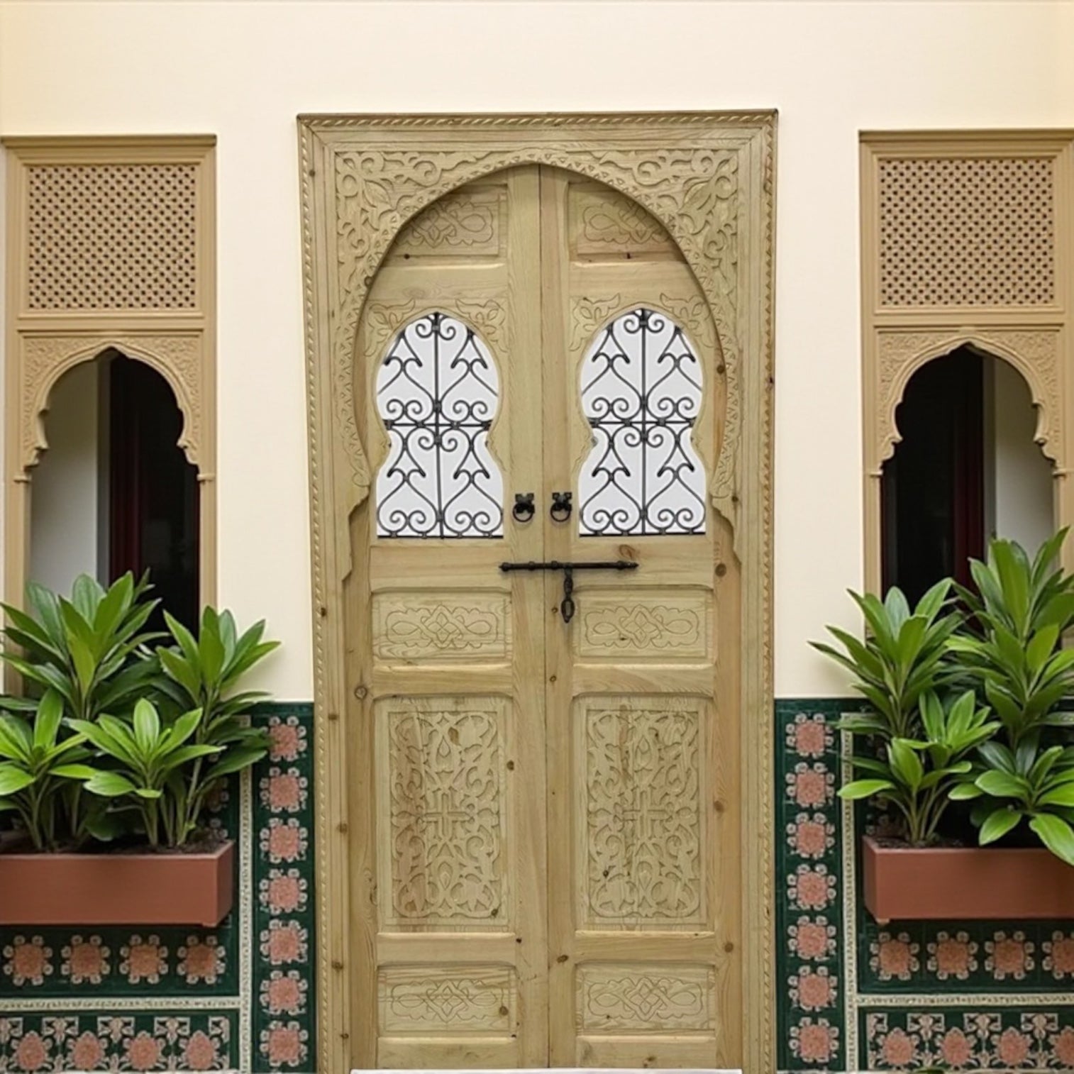 Decorative Marrakech-style wooden door with intricate carvings, featuring traditional design and warm brown finish.