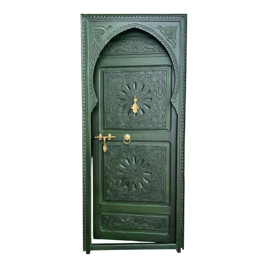 Green Andalusian door with intricate carvings and wrought iron details, showcasing traditional Spanish craftsmanship.
