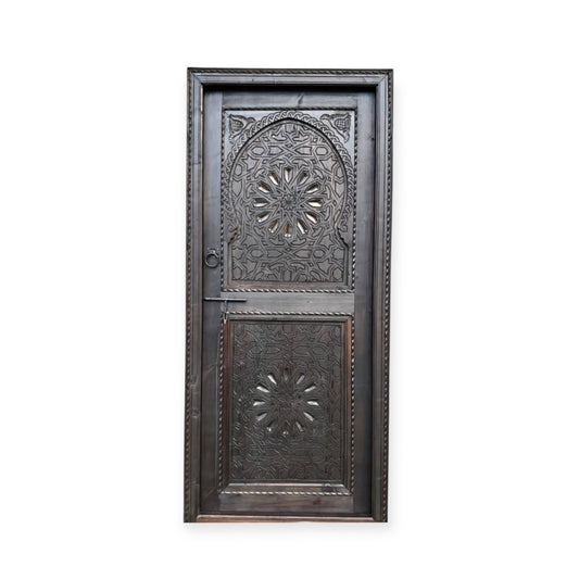 Decorative Riad door with intricate carvings and traditional design, featuring warm wood tones and detailed craftsmanship.