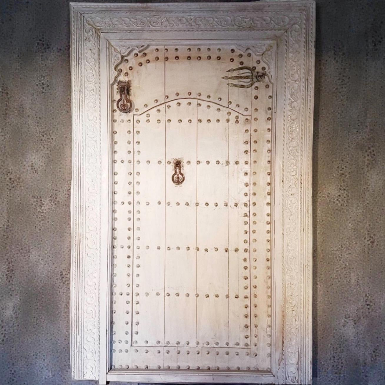 Large vintage Moroccan Marrakesh riad door with intricate metalwork and traditional design, showcasing an ornate, historic entrance.