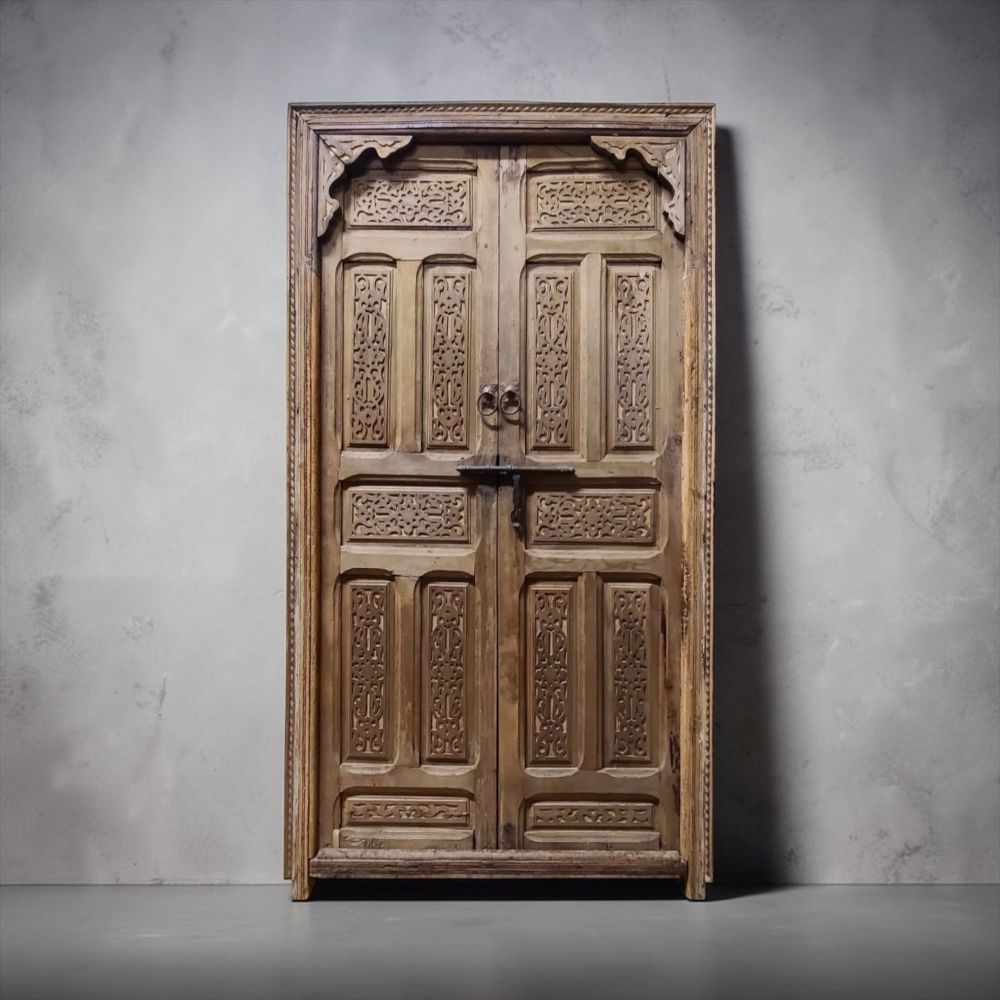 Vintage Moroccan Cordoba door with intricate wood carvings and iron accents, showcasing traditional craftsmanship.