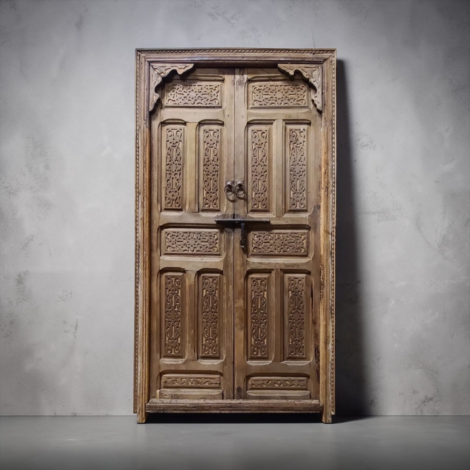 Vintage Moroccan Cordoba door with intricate wood carvings and iron accents, showcasing traditional craftsmanship.